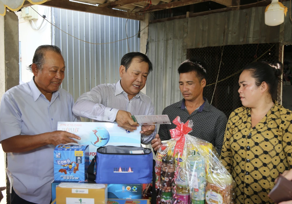 Tổng Biên tập Báo Pháp Luật TP.HCM Mai Ngọc Phước hướng dẫn anh Mai Văn Phước sử dụng các dụng cụ đi biển được tặng.