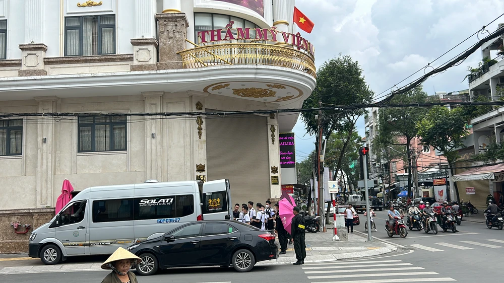 Nhân viên thẩm mỹ viện hỗ trợ đưa các vật dụng tài liệu lên xe . Ảnh: HD