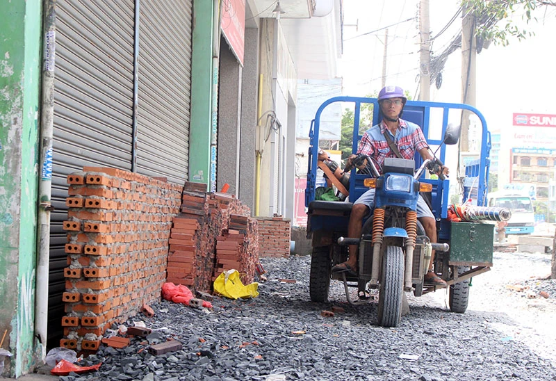 Đồng ý giữ nguyên độ cao vỉa hè đường Kinh Dương Vương ảnh 2 Việc nâng đường Kinh Dương Vương đã gây nhiều bức xúc trong người dân địa phương. Ảnh: LÊ THOA