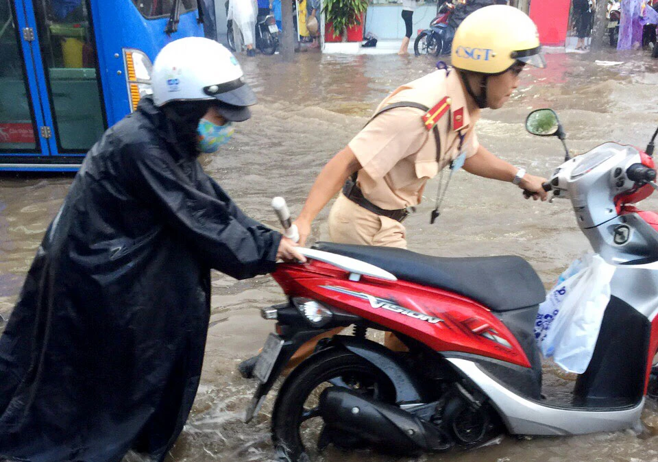 CSGT quận 12 giúp dân 'cứu' xe chết máy qua điểm ngập ảnh 4