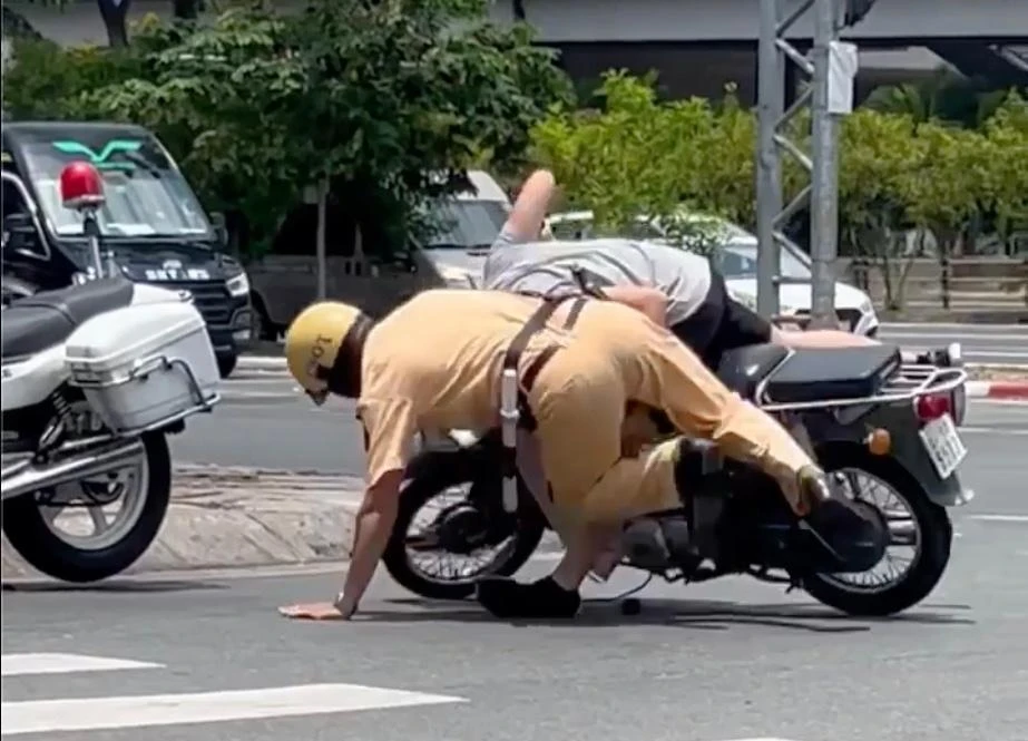 CSGT vật ngã nam thanh niên xuống đường. Ảnh: cắt từ clip