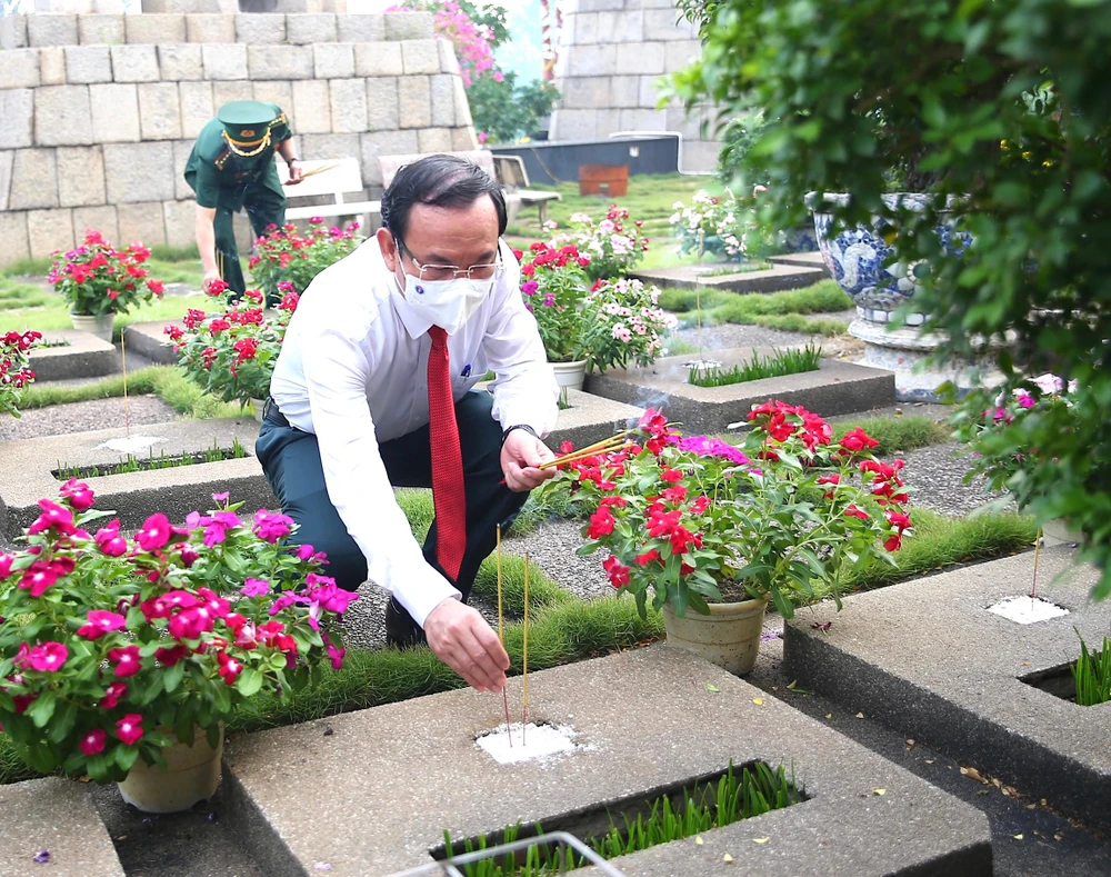 Bí thư Thành uỷ TP.HCM Nguyễn Văn Nên thắp hương từng ngôi mộ. Ảnh: LONG HỒ