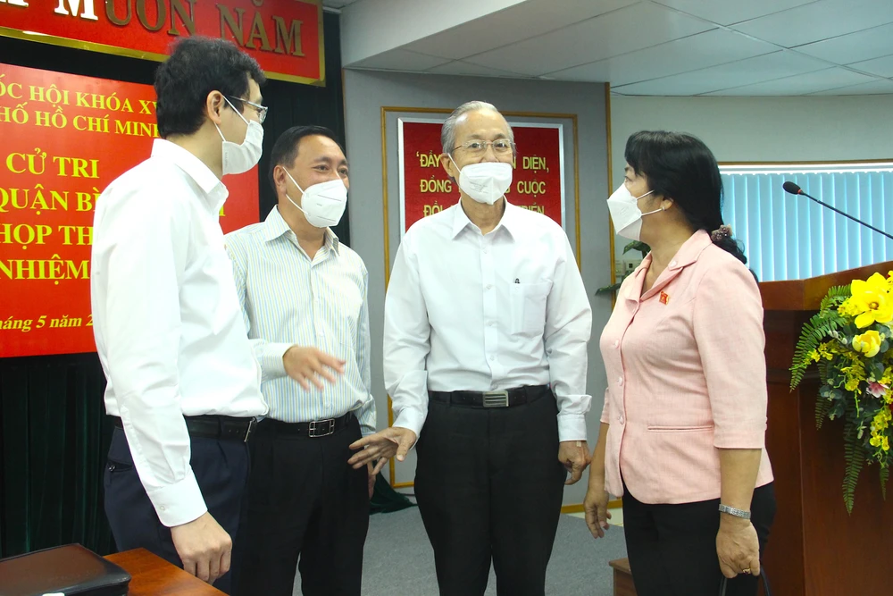 Các ĐBQH TP.HCM trao đổi với cử tri bên lề buổi tiếp xúc. Ảnh: LÊ THOA