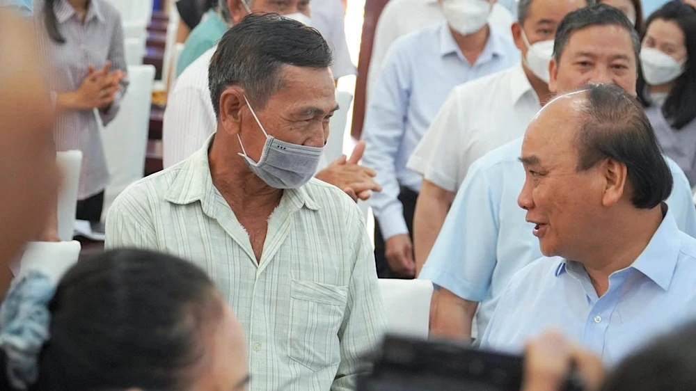 Chủ tịch nước Nguyễn Xuân Phúc trao đổi với cử tri bên lề hội nghị tiếp xúc cử tri. Ảnh: MINH TÂM