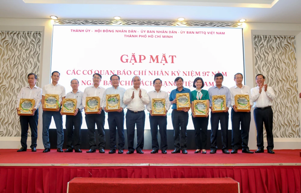 Chủ tịch nước Nguyễn Xuân Phúc và Chủ tịch UBND TP.HCM Phan Văn Mãi tặng quà và chúc mừng lãnh đạo các cơ quan báo chí TP.HCM. Ảnh: THU THẢO