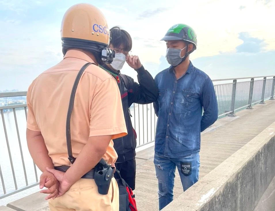 CSGT TP.HCM tiếp cận ngăn cản thanh niên định nhảy cầu Phú Mỹ. Ảnh: NSG