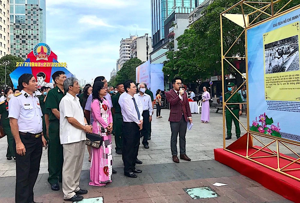 Phó Bí thư Thành uỷ TP.HCM Nguyễn Văn Hiếu cùng các đại biểu tham quan triển lãm ảnh. Ảnh: NGUYỄN BÍCH