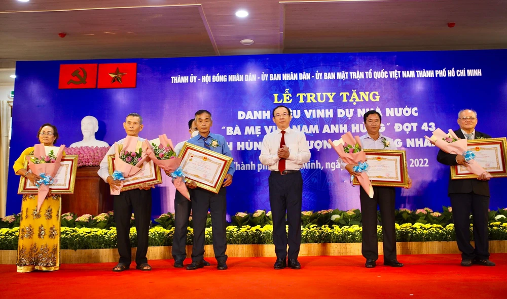 Bí thư Thành uỷ TP.HCM Nguyễn Văn Nên trao quyết định truy tặng danh hiệu "Bà Mẹ Việt Nam anh hùng" cho gia đình các Mẹ. Ảnh: NGUYỆT NHI
