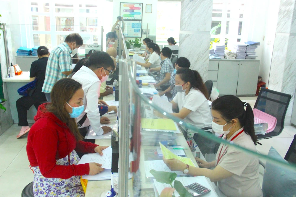 Cán bộ quận 1 đang giải quyết thủ tục cho người dân. Ảnh: LÊ THOA