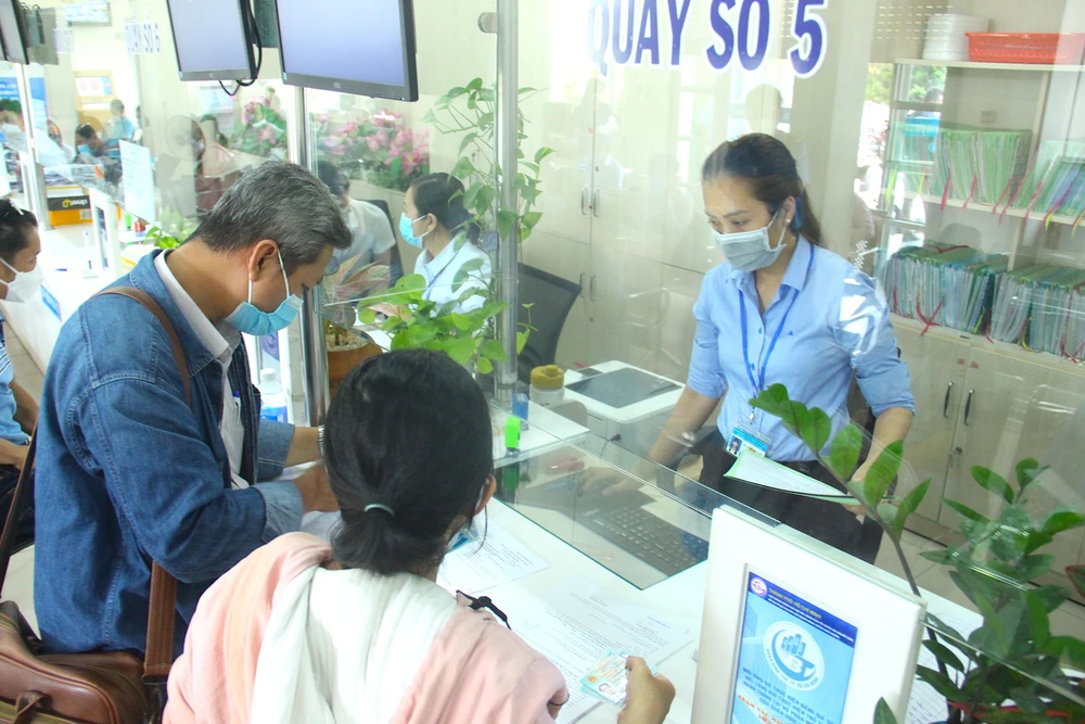 Cán bộ quận Bình Tân giải quyết hồ sơ cho người dân. Ảnh: LÊ THOA