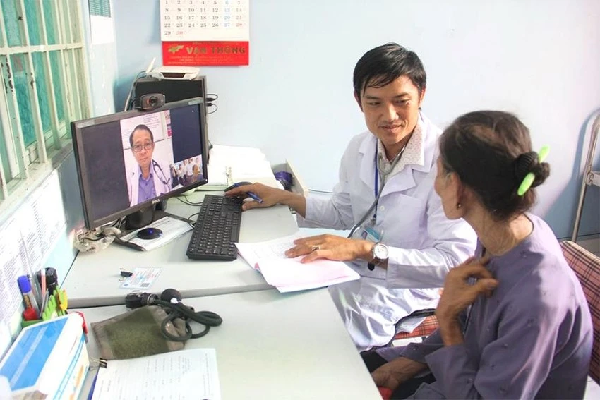 Bác sĩ Trạm y tế xã Tân Nhựt (huyện Bình Chánh, TP.HCM) khám cho bệnh nhân bằng phần mềm hội chẩn từ xa với bệnh viện tuyến trên. Ảnh: NVCC