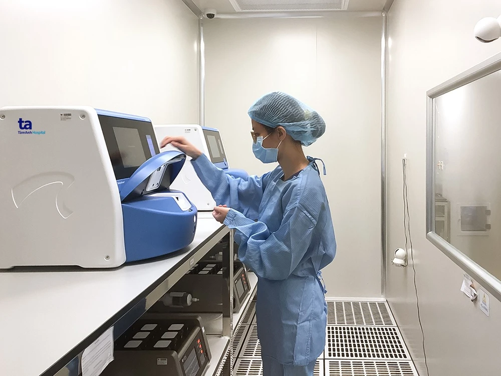 Chuyên viên phôi học đang đặt đĩa phôi vào trong tủ nuôi phôi có camera quan sát 24/24h. Ảnh: Tuệ Diễm