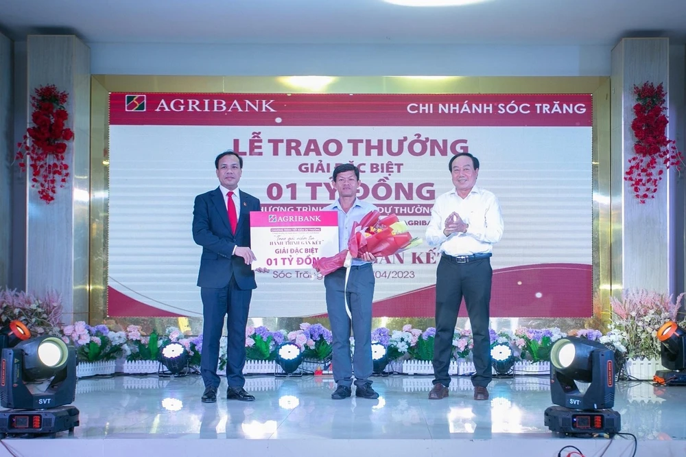 Đại diện lãnh đạo Agribank, Phó Tổng giám đốc Lê Hồng Phúc trao 1 tỷ đồng cho khách hàng trúng giải Đặc biệt.