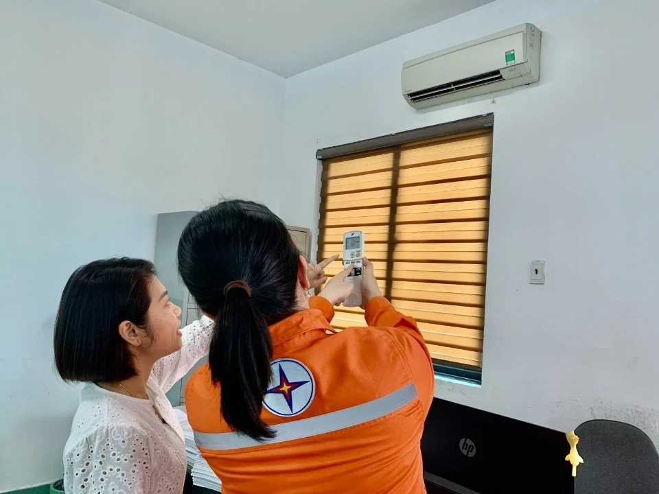 Nhân viên điện lực hướng dẫn khách hàng sử dụng thiết bị điện hiệu quả.