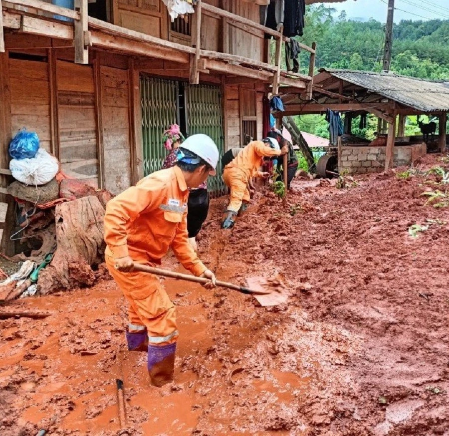 Nhân viên điện lực đồng hành với người dân khắc phục hậu quả đợt mưa lũ đầu tháng 8 vừa qua.