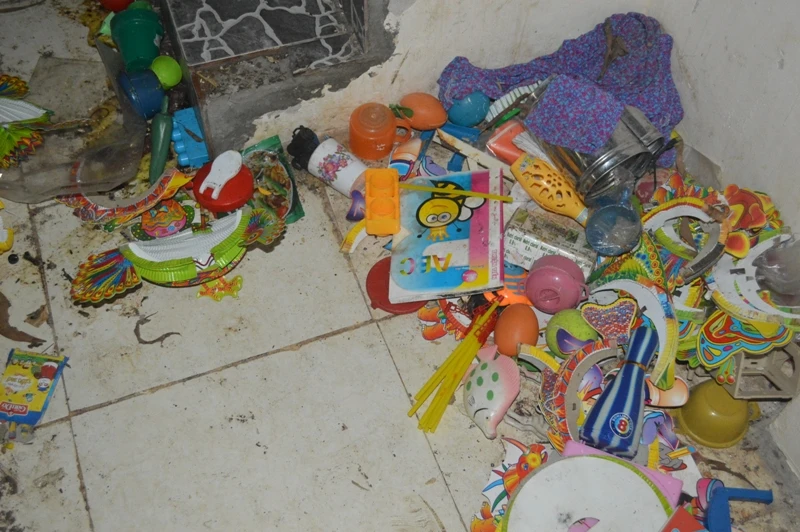 Đồ chơi, tập vở vứt la liệt dưới nền nhà