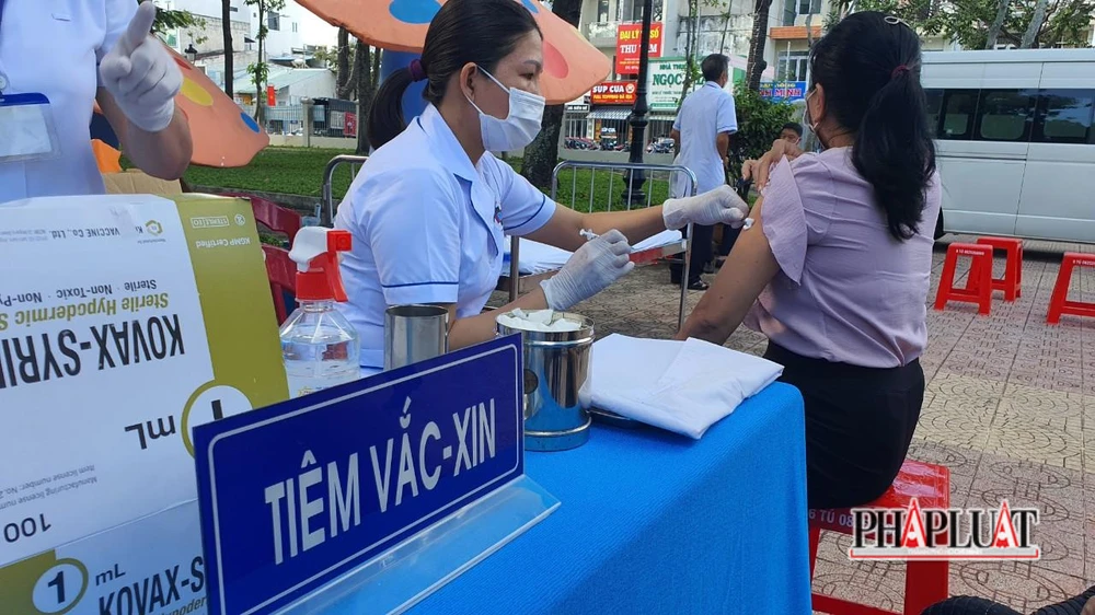 Cán bộ, người dân đến tiêm vaccine mũi tăng cường phòng, chống COVID-19 sáng 30-8. Ảnh: TK