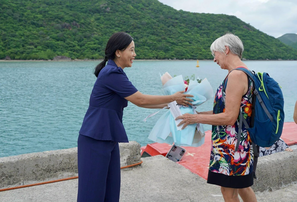Bà Nguyễn Thụy Nga, Phó Chủ tịch UBND huyện Côn Đảo tặng hoa chào mừng du khách quốc tế. Ảnh:MC.