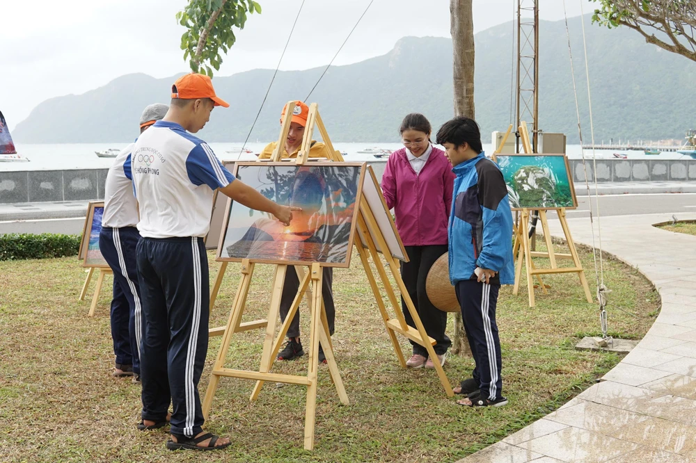 Các bạn trẻ tham quan triển lãm ảnh. Ảnh: TT