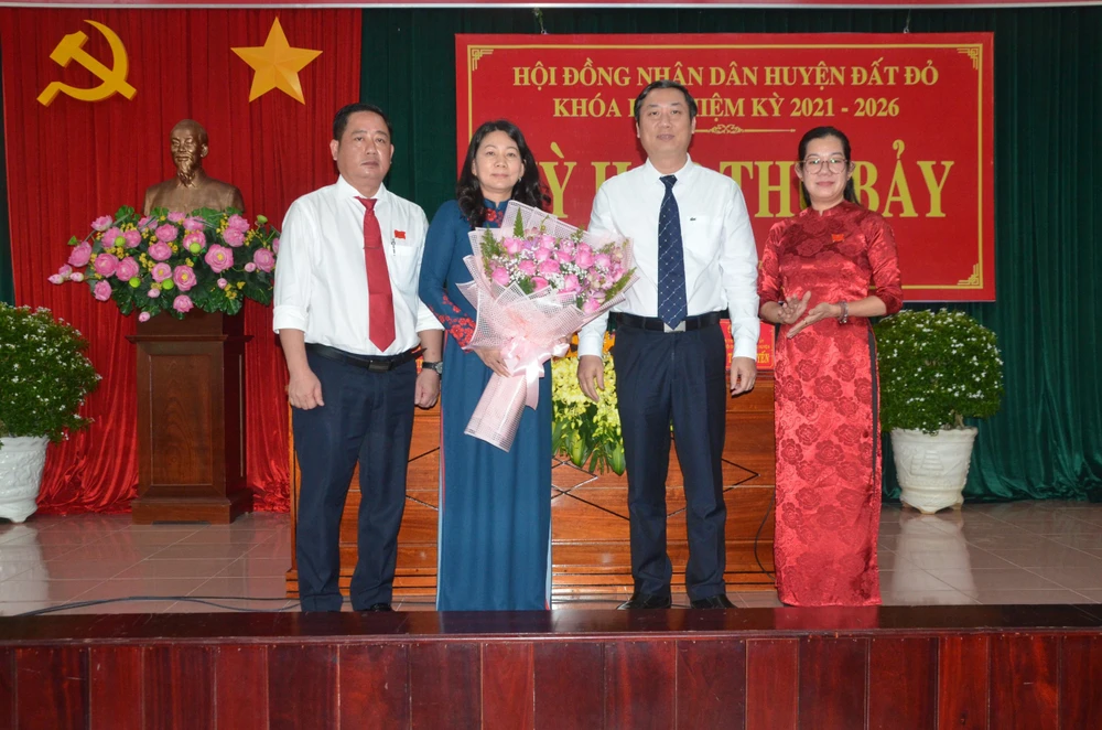 Ông Trần Thanh Hùng và bà Đỗ Thị Hồng (bên trái ảnh) nhận hoa chúc mừng từ ông Nguyễn Công Danh, Bí thư huyện Đất Đỏ. Ảnh:VA