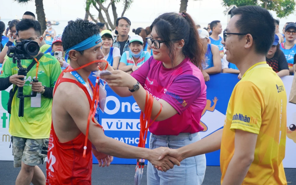 Trao huy chương cho một VĐV về đích. Ảnh: VQ