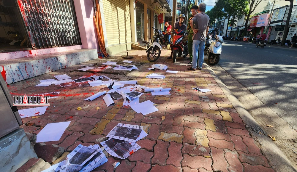 Nhiều giấy đòi nợ trước cửa căn nhà bị tạt sơn.