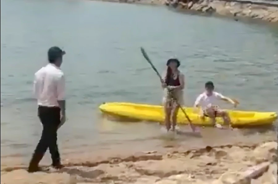 Người tự xưng nhân viên một khu du lịch ra xua đuổi, yêu cầu du khách nước ngoài đang chơi dưới biển phải lên bờ. Ảnh cắt từ clip.