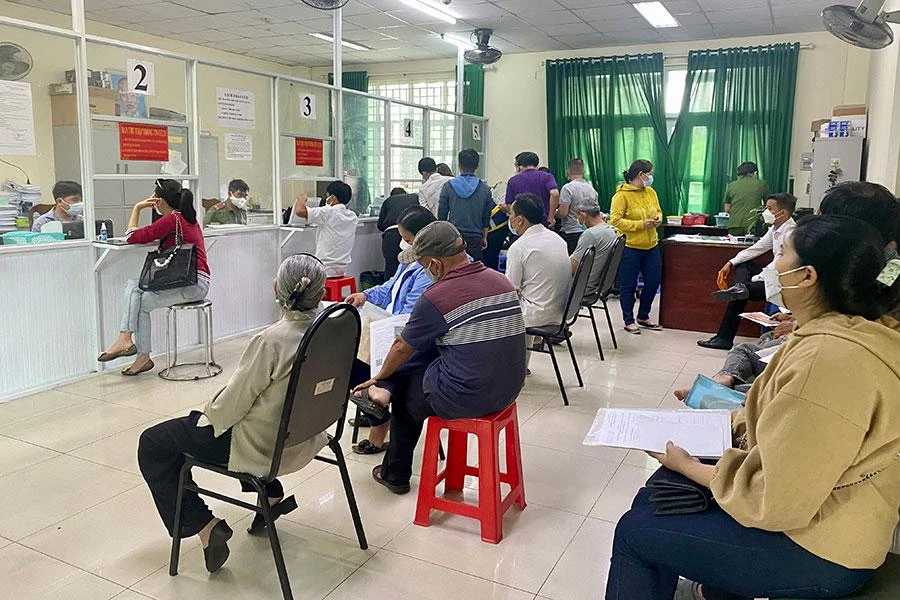 Người dân ngồi chờ để đến lượt làm CCCD tại trụ sở Công an huyện Bình Chánh. Ảnh: HỮU ĐĂNG