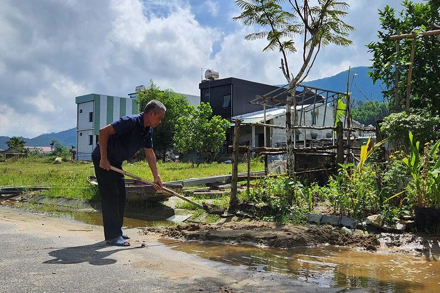 Nước mưa ứ đọng trước căn nhà tạm của ông Hồ Phú Sâm tại khu tái định cư trung tâm xã Hòa Bắc. Ảnh: TẤN VIỆT