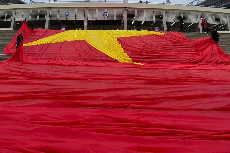 Trưa mùng 1 tết, khi mọi người đang chung vui chúc tết ngày đầu năm thì nhóm cổ động viên VGS đã đưa lá đại kỳ đến sân Mỹ Đình và bắt đầu việc căng lá cờ 3.000 m2, nặng 450 kg phủ hết khán đài D. Ảnh: H.YẾN Trưa mùng 1 tết, khi mọi người đang chung vui chúc tết ngày đầu năm thì nhóm cổ động viên VGS đã đưa lá đại kỳ đến sân Mỹ Đình và bắt đầu việc căng lá cờ 3.000 m2, nặng 450 kg phủ hết khán đài D. Ảnh: H.YẾN
