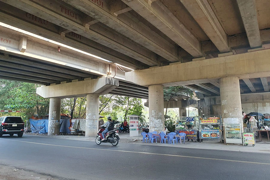 Gầm cầu Ông Lớn (đường Nguyễn Văn Linh) bị chiếm dụng làm quán ăn và khu vực sinh hoạt của người dân. Ảnh: KC Gầm cầu Ông Lớn (đường Nguyễn Văn Linh) bị chiếm dụng làm quán ăn và khu vực sinh hoạt của người dân. Ảnh: KC