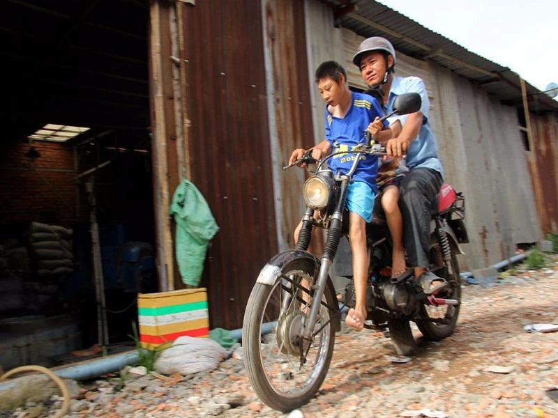 Ba cha con đèo nhau trên chiếc xe máy cà tàng