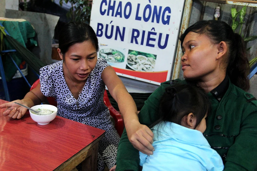 Bé Ngọc Yến làm nũng với mẹ nuôi Thị Liên khi được mẹ ruột Thu Trang cho ăn. Ảnh: HOÀNG GIANG