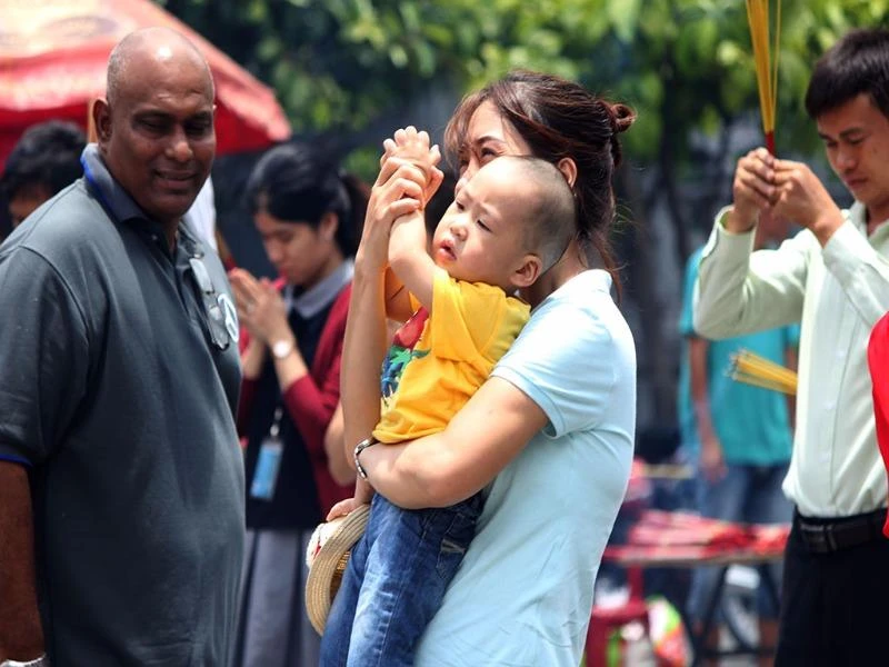 Người mẹ đang hướng dẫn con nhỏ chắp tay cầu nguyện