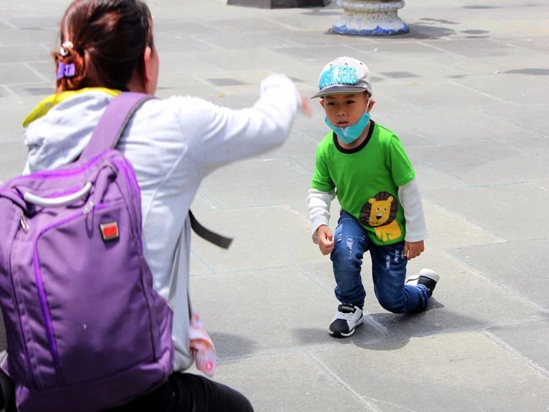 Một em nhỏ được mẹ chụp hình khi đến chùa.