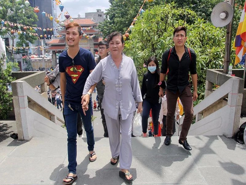 Người mẹ được con trai đưa đến chùa cầu an