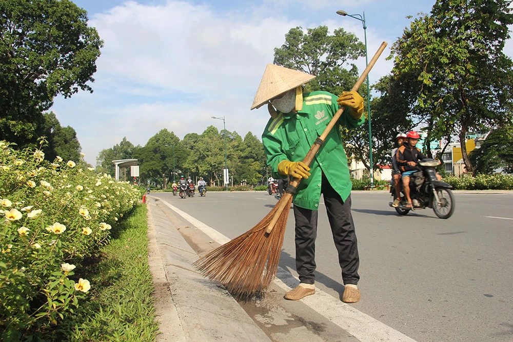 Công nhân làm vệ sinh tuyến đường vừa mới thông xe.