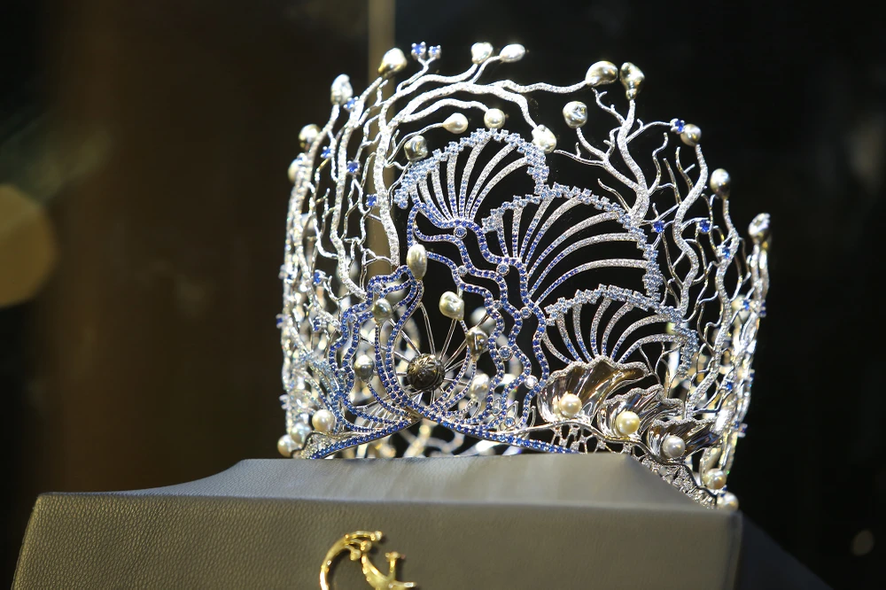 Viên ngọc Trống Đồng biểu trưng văn hóa dân tộc thể hiện trên vương miện được chế tác từ ngọc trai Tahiti sắc đen quyền quý. Ngọc trai Trống Đồng cũng từng được sử dụng trong chế tác các tặng phẩm quốc gia dành cho phu nhân phu nhân tổng thống Mỹ Barack Obama, phu nhân thủ tướng Nhật Shinzo Abe cùng nhiều phu nhân nguyên thủ quốc gia, nữ lãnh đạo trên thế giới.