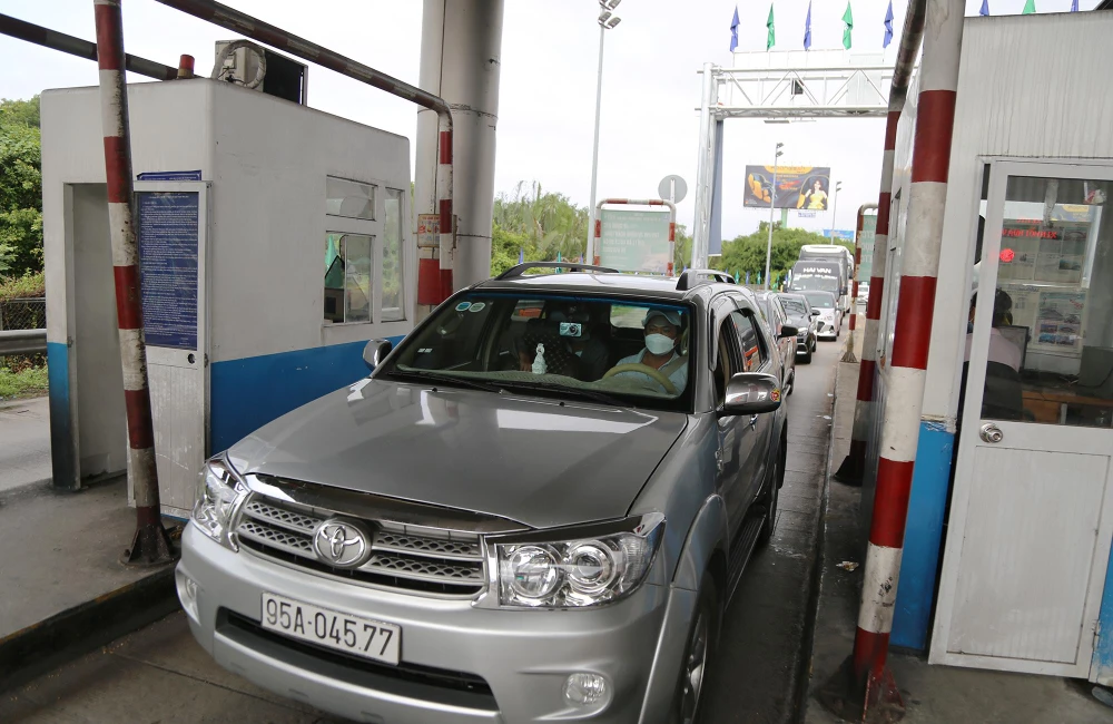 Xe cộ lưu thông hướng TP.HCM đi qua trạm thu phí một cách nhanh chóng.