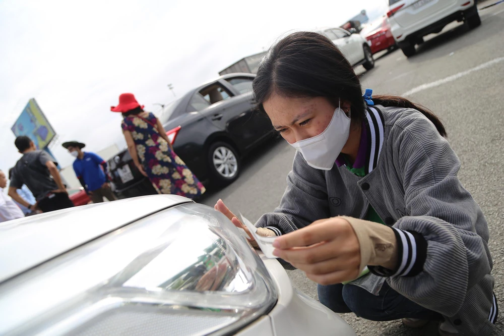 Nhân viên dán thẻ cho xe lưu thông qua trạm thu phí Long Phước sáng 1-8.