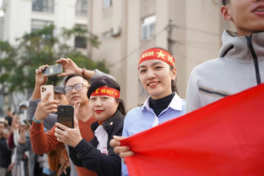 Người hâm mộ chờ đoàn xe Đội tuyển bóng đá Việt Nam đi qua trên đường Âu Cơ.