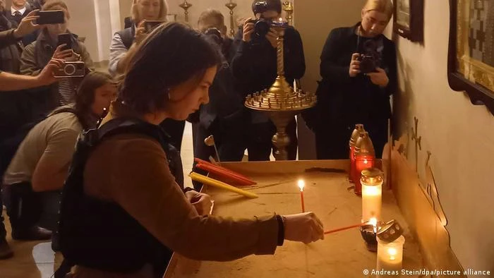 Ngoại trưởng Đức Annalena Baerbock thắp nến tưởng nhớ các nạn nhân trong một nhà thờ ở Bucha. Ảnh: DPA