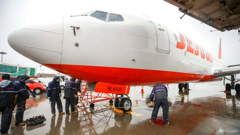 Thợ máy của hãng hàng không Jeju Air (Hàn Quốc) buộc một chiếc máy bay trên đường băng tại sân bay quốc tế Gimpo ở Seoul (Hàn Quốc) ngày 5-9. Ảnh: AP