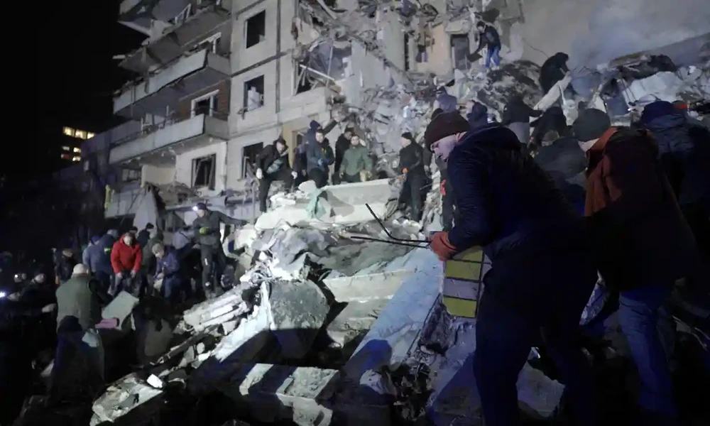 Lực lượng cứu hộ dọn dẹp đống đổ nát tại một tòa nhà dân cư bị phá hủy sau cuộc tấn công bằng tên lửa ở Dnipro. Ảnh: AFP.