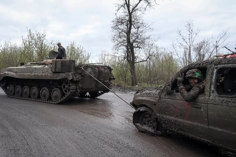Các binh sĩ Ukraine kéo một chiếc ô tô bị hư hại tại ở TP Chasiv Yar gần Bakhmut ngày 22-4. Ảnh: REUTERS