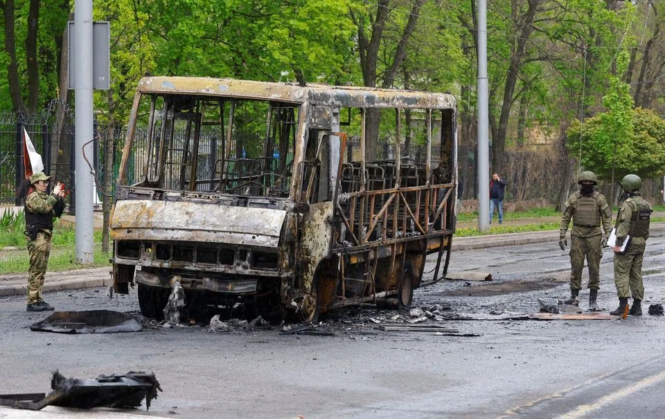 Một xe buýt nhỏ bị thiêu rụi sau khi trúng pháo kích ở TP Donetsk, tỉnh Donetsk. Ảnh: REUTERS