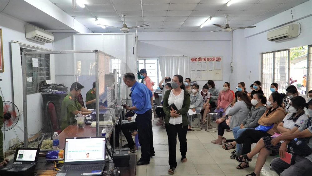 Người dân, phụ huynh và học sinh ngồi trật tự đợi làm CCCD. Ảnh: MINH TÂM