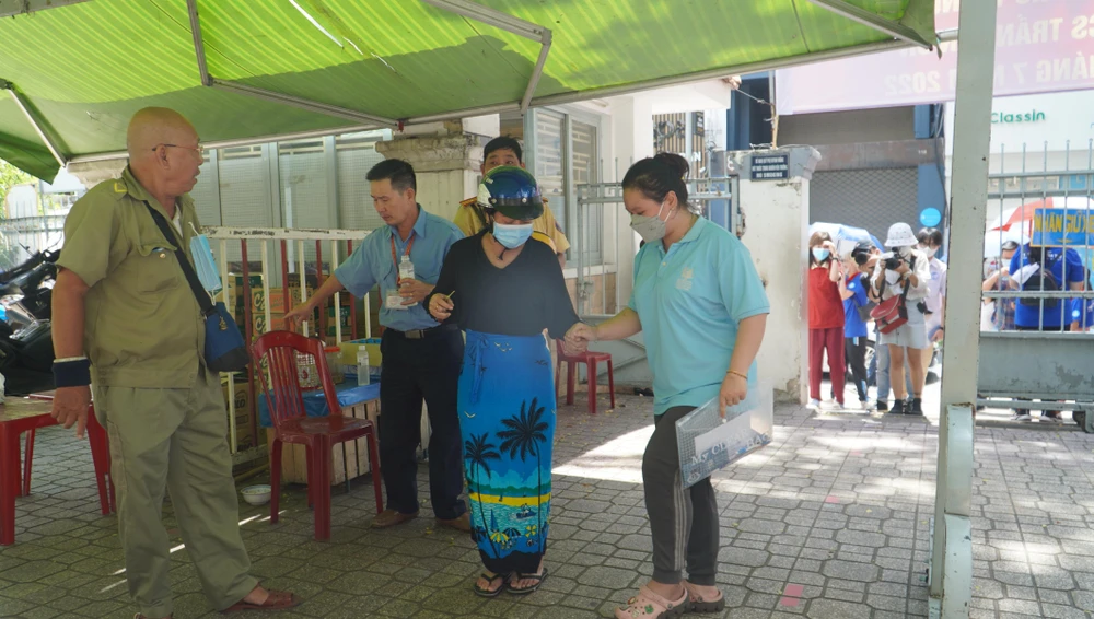 Mẹ Bảo Nhi dìu vào bên trong và nhờ cán bộ coi thi đưa em lên phòng thi.