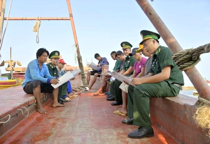BĐBP Đồn Biên phòng Xà Lực cấp phát tờ rơi tuyên truyền về chống khai thác IUU cho ngư dân trước khi xuất bến đánh bắt hải sản
