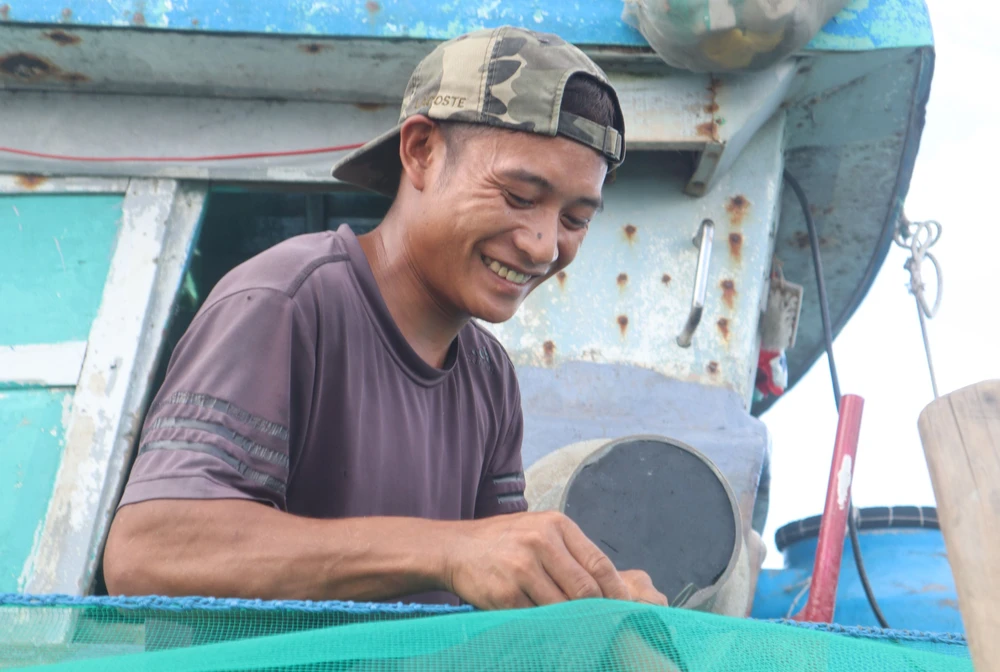 Niềm vui của ngư dân khi chuẩn bị ngư cụ, lưới cá cho chuyến ra khơi. Ảnh: Khánh Ly